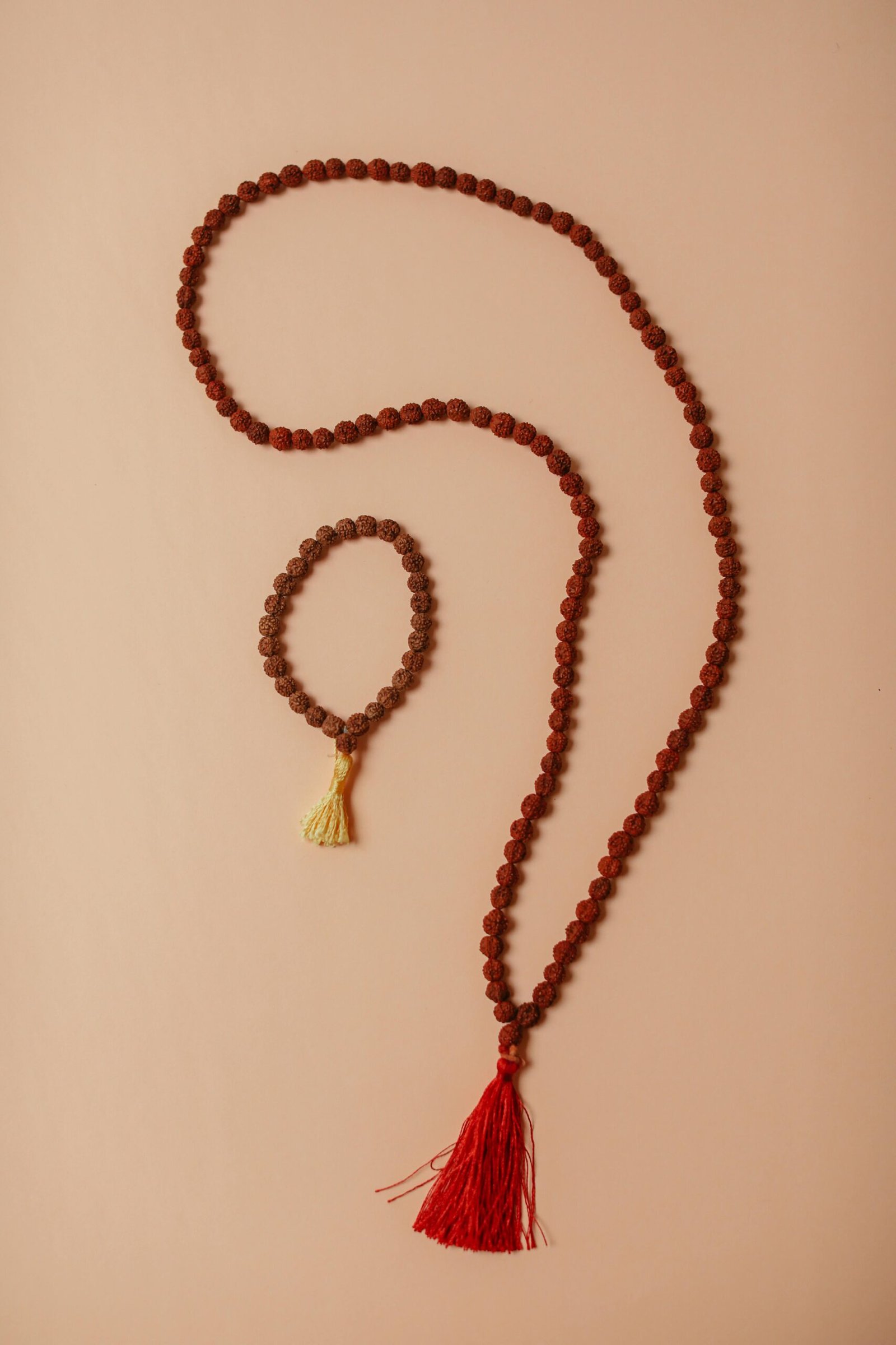 Beautiful arrangement of rudraksha beads on a beige background, showcasing traditional craftsmanship.